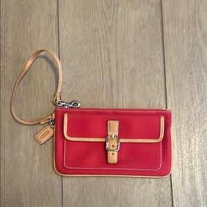 Coach wristlet. Red with tan edging. Snap pocket in front.